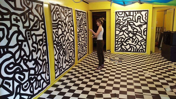 Hand-painted black and white panels in a yellow room with a chequered floor