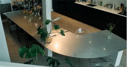 The table top curving through the kitchen