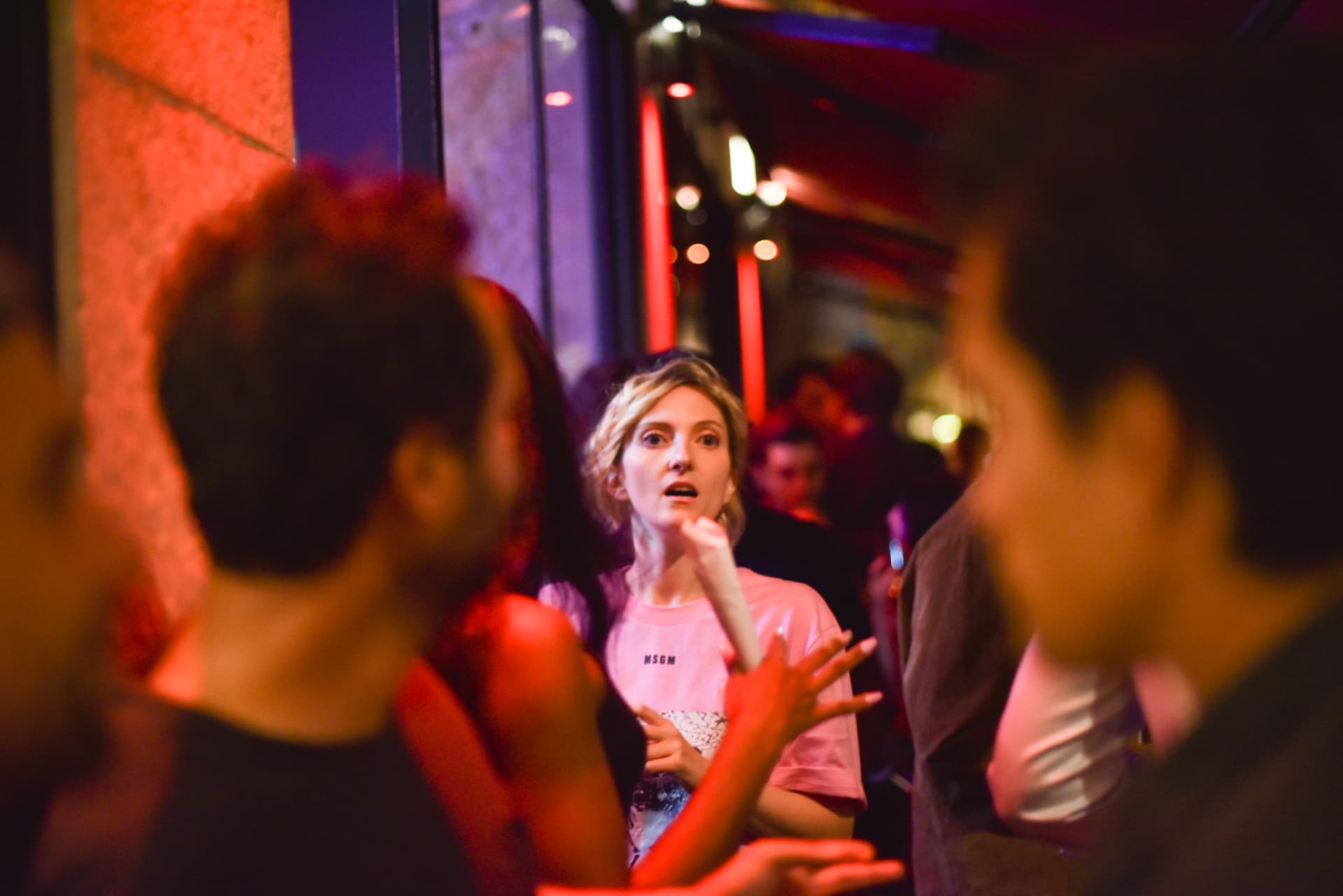 Susan Isko mid-conversation in a crowded, neon-lit club during an event.